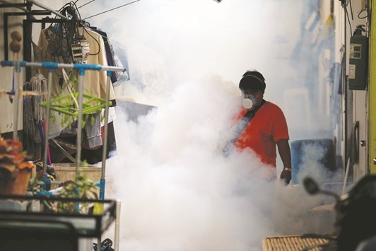 A city worker fumigating the area to control the spread of mosquitoes at a university in Bangkok.