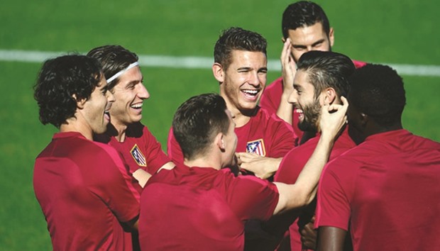 Atletico Madridu2019s players joke during a training session at the Football City in Las Rozas near Madrid yesterday, on the eve of their Champions League football match against Bayern Munich. (AFP)