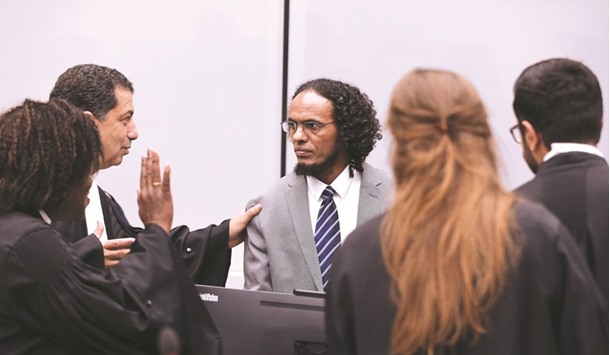Malian jihadist Ahmad al-Faqi al-Mahdi (C) speaks with his lawyer Mohamed Aouini (L) at the International Criminal Court (ICC) in The Hague on September 27, 2016, during his sentencing for destroying Timbuktuu2019s shrines. Mahdi was sentenced to nine years in jail for destroying the shrines, after he was found guilty of directing the 2012 attacks on the Unesco world heritage site in northern Mali.