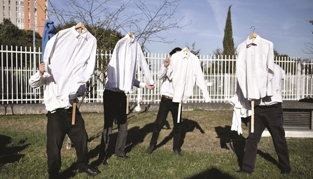 Performers from a small theatre company hold shirts as they rehearse their act yesterday near the Bobigny courthouse, northeast of Paris, as a trial over rowdy scenes a year ago in which an Air France executive had his shirt ripped is being held in court.