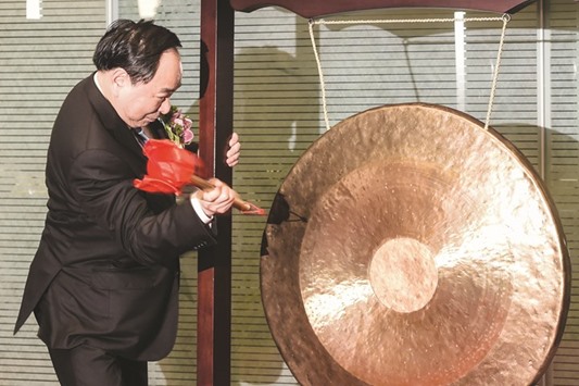 Li Guohua, chairman of Postal Savings Bank of China, bangs a gong during the companyu2019s listing on the cityu2019s stock exchange in Hong Kong yesterday.