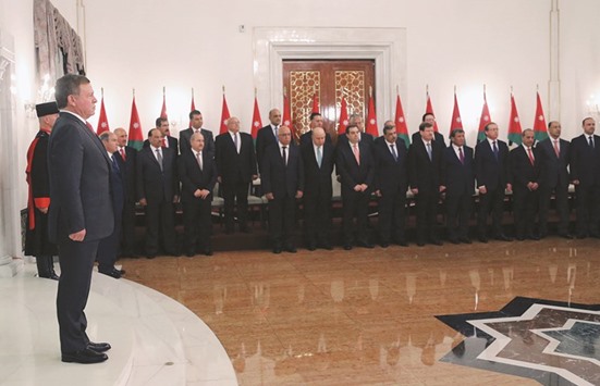 Jordanian King Abdullah II stands in front of his prime ministeru2019s new government during a swearing in ceremony in the capital Amman.