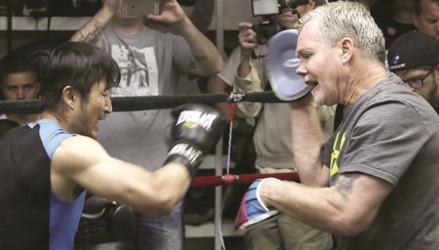 A file photo shows Zou Shiming (left) spars with trainer Freddie Roach.