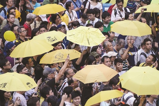 Activists hold yellow umbrellas, a symbol of the pro-democracy movement, as they observe three minutes of silence to mark the moment tear gas was used by police on the same day in 2014, in front of the government headquarters in Hong Kong yesterday.