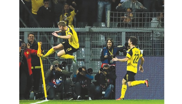 Dortmundu2019s midfielder Andre Schuerrle (L) reacts after scoring against Real Madrid at BVB stadium in Dortmund.