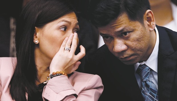 Maia Santos Deguito, a branch manager of RCBC, whispers to her lawyer as she testifies during a hearing at the Philippine Senate in Manila on April 12.