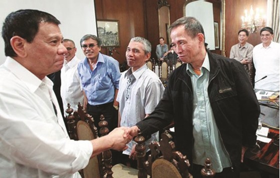 President Rodrigo Duterte shakes hands with communist leader Benito Tiamzon in Malacanang.