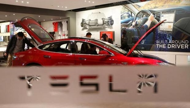 A man looks at a Tesla car in Beijing in this file picture.