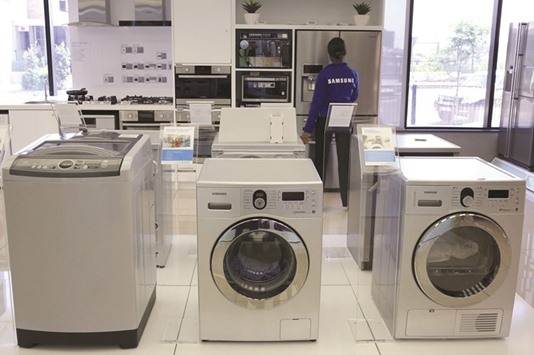 An employee inspects Samsung washing machines at a display store in Johannesburg. The US Consumer Product Safety Commission yesterday warned of problems with some of the companyu2019s top-load washing machines, following media reports that they had exploded.