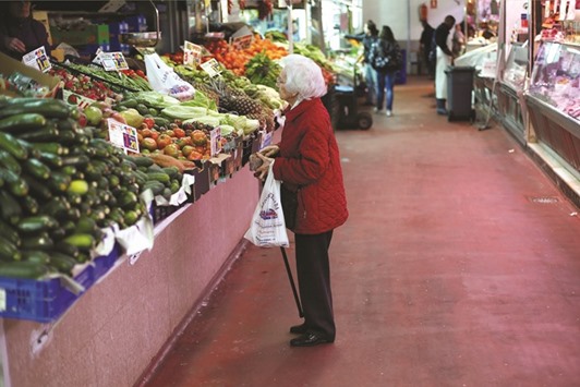 A woman looks at fruits and vegetables at a market in Madrid. German inflation picked up in September to reach its highest level in 16 months and Spanish consumer prices rose for the first time since May 2014.