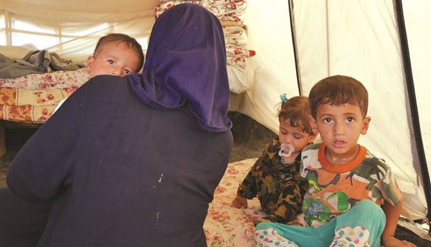 Asil, from Makhmour, southeast of Mosul, sits with her three children in Debaga camp.