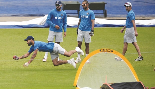 Indiau2019s captain Virat Kohli (left) dives to take a catch as Rohit Sharma (second from left), Shikhar Dhawan and Gautam Gambhir (right) look on during a training session in Kolkata yesterday. The second Test between India and New Zealand starts in Kolkata today. (AFP)