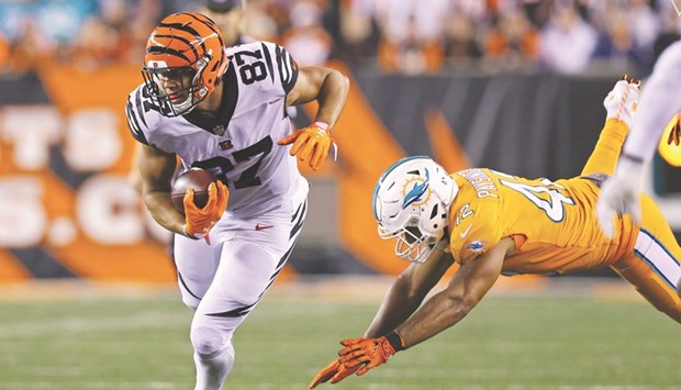 Cincinnati Bengals tight end C.J. Uzomah (87) carries the ball past Miami Dolphins linebacker Spencer Paysinger (42) in the first half of their NFL game on Thursday. PICTURE: Aaron Doster-USA TODAY Sports