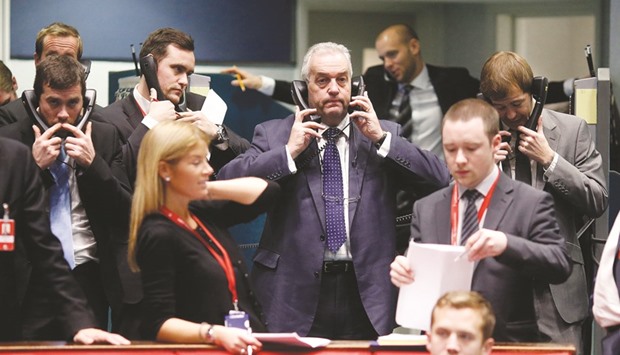 Traders use telephones as they work on the trading floor at the London Metal Exchange. The LME has confirmed it will cap both rents and load-out charges across its physical delivery network effective next year.
