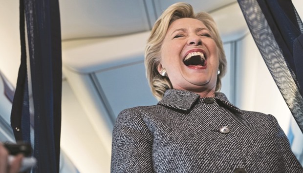 Democratic presidential nominee Hillary Clinton laughs at a question about her favourite world leader while speaking to the press on her plane at the Chicago Midway Airport, in Chicago, Illinois.