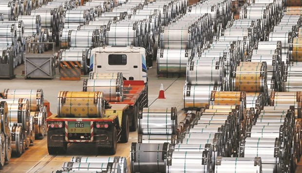 A truck drives past rolls of steel inside the China Steel Corporation factory. Chinau2019s factory activity expanded in September as domestic and export orders picked up but the improvement was marginal and manufacturers continued to shed jobs, a private business survey showed yesterday.