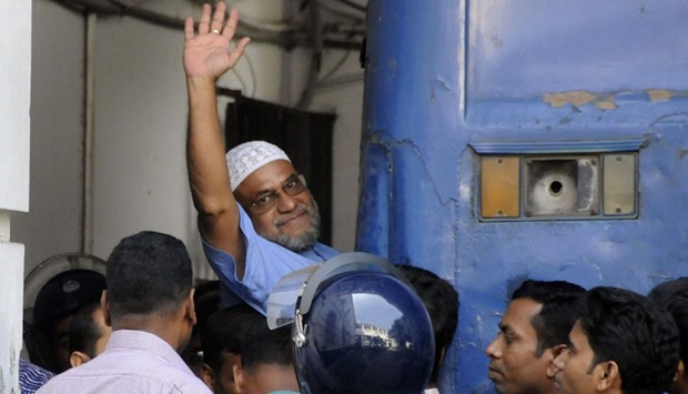 Bangladeshi Jamaat-e-Islami party leader, Mir Quasem Ali waving as he enters a van at the International Crimes Tribunal court in Dhaka. File photograph taken on November 2, 2014. AFP