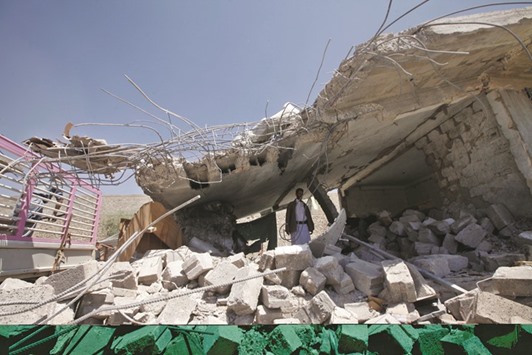 A man stands on rubble from destruction at the site of an air strike by Arab coalition in Sanaa,Yemen, yesterday.