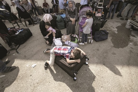 Palestinians wait for travel permits to cross into Egypt through the Rafah border crossing, yesterday in the southern Gaza Strip. Egyptian authorities temporarily reopened it both directions for two days in Gaza Strip. Patients, people with residence permit and passport owners are allowed to cross to border.