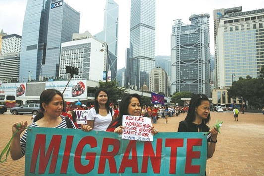 Domestic helpers hold a banner as they take part in the protest in Hong Kong yesterday.