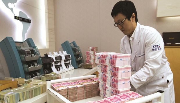 An employee arranges yuan banknotes at the Korea Exchange Bank headquarters in Seoul. The currency has dropped 0.5% versus the dollar since the start of August as Chinese data failed to quell concerns over the nationu2019s economic health and the Federal Reserve indicated it could raise borrowing costs this year.