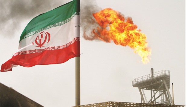 A gas flare on an oil production platform is seen alongside an Iranian flag. The Opec member can raise production to 4mn bpd in two to three months from the current daily level of about 3.8mn, Mohsen Ghamsari, director of international affairs at state-run National Iranian Oil Co, said in Singapore yesterday.