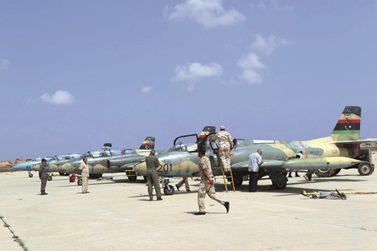 Staff members of the Libyan Air Force next to fighter jets on the tarmac of the Air College, that was turned into an air base for jets targeting the positions of the Islamic State (IS) group in Sirte as well as in the north-central and north-western Libya.