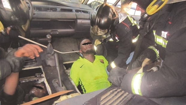 This handout photo taken on Sunday and released yesterday by the Spanish authorities shows firefighters freeing migrants from a false bottom below the front seats of a vehicle in the Spanish enclave of Melilla.