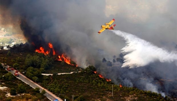 A seaplane drops water over a wildfire near the Spanish resort of Javea, Valencia region.