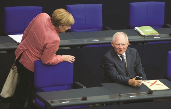 German Finance Minister Wolfgang Schaeuble and Chancellor Angela Merkel attend a meeting at the lower house of parliament Bundestag on 2017 budget in Berlin yesterday. Schaeuble cited unemployment at the lowest since East and West Germany reunited in 1990, u201chealthyu201d economic growth and rising wages and retirement benefits.