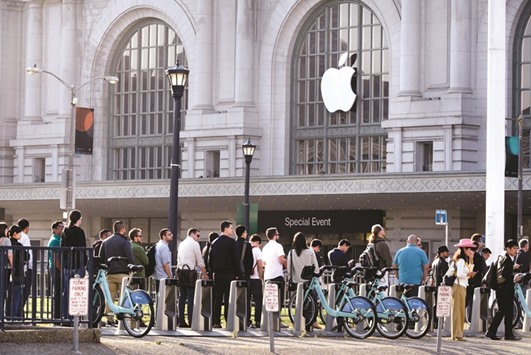 Attendees stand in line outside of the Bill Graham Civic Auditorium before the start an Apple event in San Francisco yesterday. Apple chief executive Tim Cook revealed new information on latest Apple products at the event.