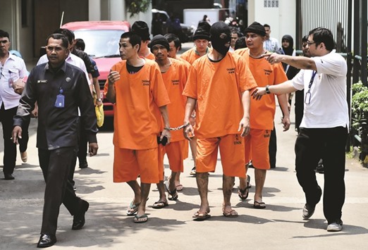 Indonesian national narcotics agency (BNN) and national criminal police detectives parade foreign and local drug traffickers in Jakarta yesterday.
