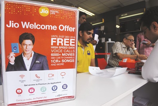 Customers wait to purchase Reliance Jio Infocomm 4G mobile service SIM cards at a store in Mumbai.