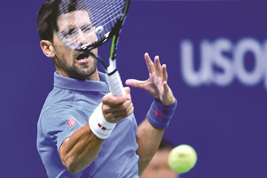 Novak Djokovic of Serbia hits a return against Jo-Wilfried Tsonga of France during their US Open quarter-final at the USTA Billie Jean King National Tennis Center in New York on Tuesday. (AFP)