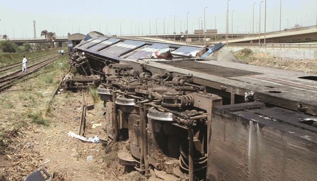 The wreckage of a train after it derailed near the village of Al-Ayyat in Giza on the southern outskirts of Cairo yesterday. The conductor suddenly hit the breaks when he spotted a problem with the tracks, causing three carriages to overturn.