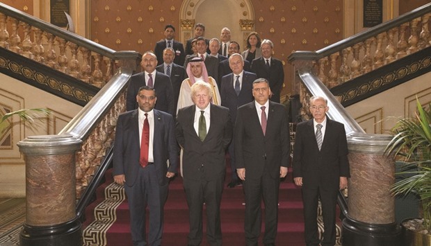 British Foreign Secretary Boris Johnson (front row second left), and Chief Negotiator for the Syrian Opposition, Dr Riyad Hijab (front row second right), stand with members of the Syrian High Negotiations Committee as they pose for a family photograph during their meeting at The Foreign Office in central London yesterday. Syriau2019s opposition set out detailed plans yesterday for the transition to a democratic state without President Bashar al-Assad ahead of talks with ministers of EU, US and regional powers in London.