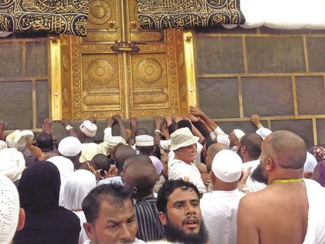 Pilgrims touch the golden doors of the Kaaba at the Grand Mosque in Makkah.