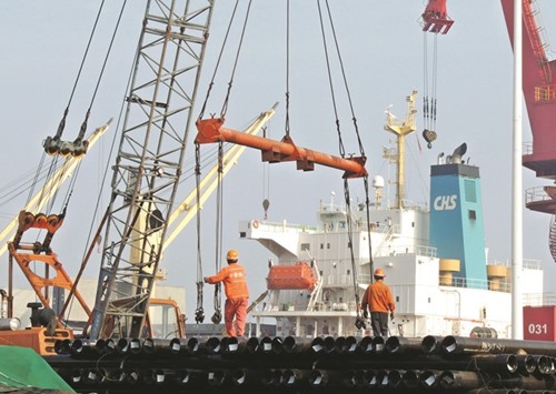 Chinese workers load steel pipes at a port in Lianyungang, Jiangsu province. Chinau2019s imports rose 1.5% year-on-year in August, figures showed yesterday.