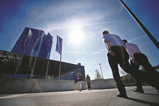 Pedestrians walk past the headquarters of the European Central Bank in Frankfurt yesterday. The euro rose after ECB economists said they now expect 1.7% growth this year, up from the 1.6% they forecast in June.