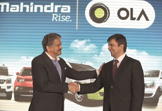 Chairman and managing director of the Mahindra and Mahindra Group, Anand Mahindra (left) shakes hands with CEO of Ola cabs, Bhavish Aggarwal during a joint press conference in Mumbai yesterday.