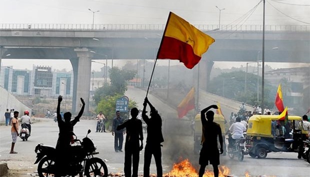 Indian activists wave the Karnataka flag as they block traffic on a major connecting road during a statewide strike in Bengaluru on Friday.