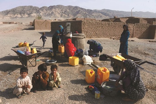 Afghan internally-displaced women wash clothes outside their temporary house on the outskirts of Herat yesterday.