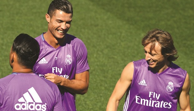 Real Madrid forward Cristiano Ronaldo (L) shares a laugh with  midfielder Luka Modric during a training session.