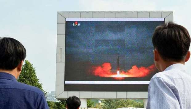 People watch a news report showing North Korea ballistic missile launch