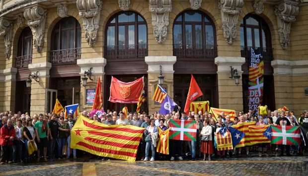 Protesters carry Esteladas, Catalan separatist flags and Basque flags, during a rally