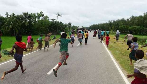 Rohingya refugee children follow a vehicle with relief supplies near the Bangladeshi town of Teknaf on Sunday.