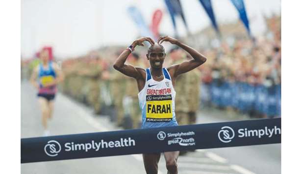 Britainu2019s Mo Farah celebrates as he crosses the finish line to win the menu2019s elite race of the Great North Run half-marathon in South Shields, England, yesterday. (AFP)