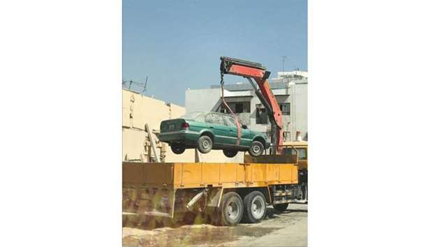 An abandoned car being removed from Al Asmakh area.