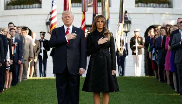 President Donald Trump and First Lady Melania Trump observe a moment of silence in remembrance of those lost in the 9/11 attacks, at the White House in Washington on Monday.