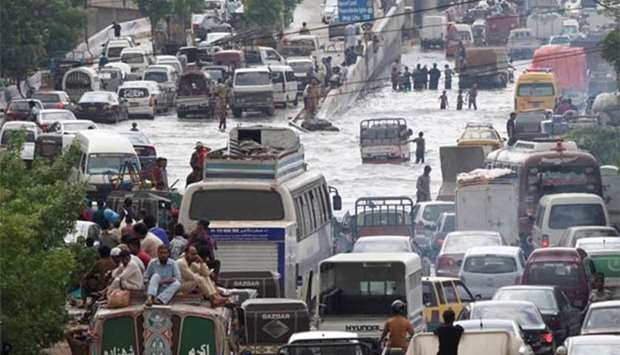 Vehicles pass through a flooded road after heavy rains in Karachi.